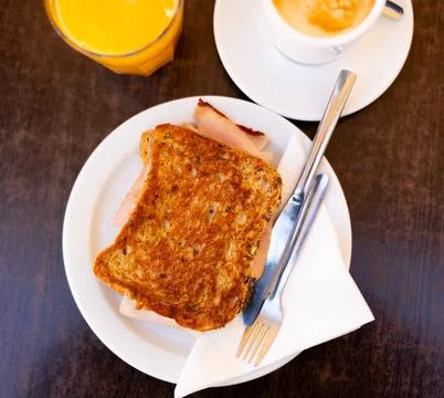 There is thin slice of soft and juicy ham between two slices of bread. 写真素材