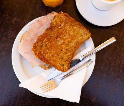 There is thin slice of soft and juicy ham between two slices of bread. Stock Photos