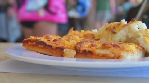 There is a white plate with a cut pie or pizza on the table in the restaurant, p Stock Footage 164678323