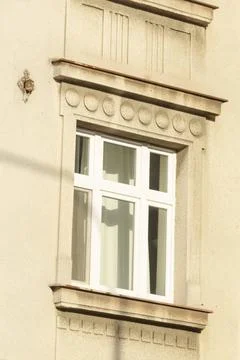 There is a window located on the side of a building featuring a white frame Foto stock