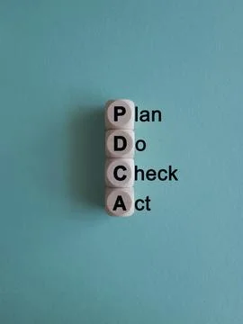 There is wood cubes with the word PDCA. Stock Photos