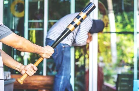 Therefore took the baseball bat as a weapon and then sneaked behind the robber Stock Photos