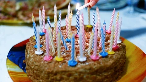 There's a cake on the table. The hand lights candles on the cake Stock Footage 103932663