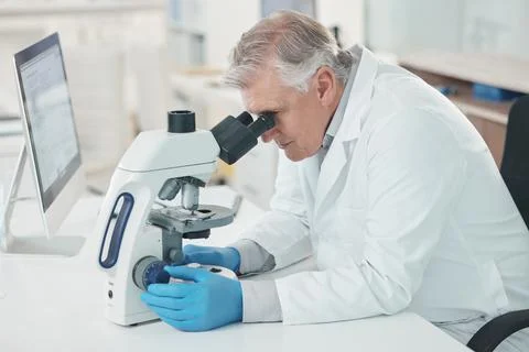 Theres a lot to take note of when magnified. Shot of a mature scientist using Stock Photos