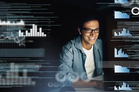 Theres no code he cannot crack. a young computer programmer looking through data Stock Photos