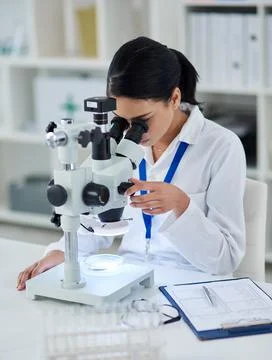 Theres nothing her microscope cant find. Shot of a young scientist using a mi Foto stock