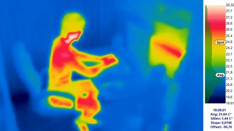 Thermal camera view, A person is working on a computer, with color scale Stock Footage 98902240