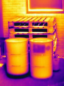 Thermal image of two oil drums outside industrial building Stock Photos