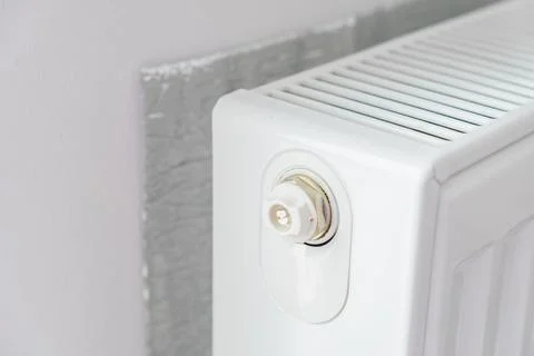 Thermal insulation panel positioned behind radiator to reflect heat into room Stock Photos