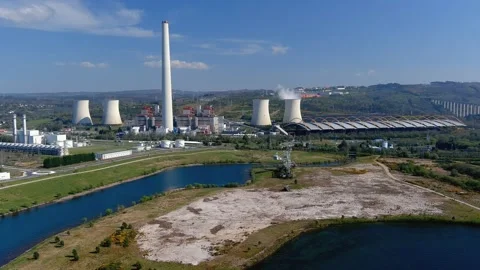 Thermal power plant with smoking chimney behind the lake and an old drill, Vidéo 200375019