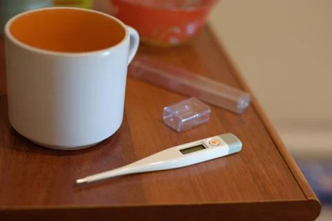 Thermometer and cup of tea on the table. respiratory disease treatment Stock Photos