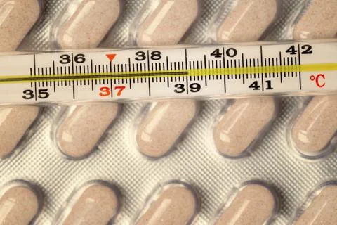 Thermometer and pills Stock Photos