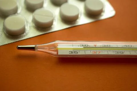 Thermometer and tablets Stock Photos