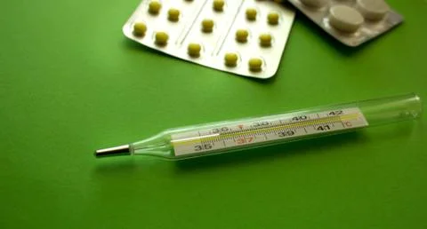 Thermometer and tablets Stock Photos