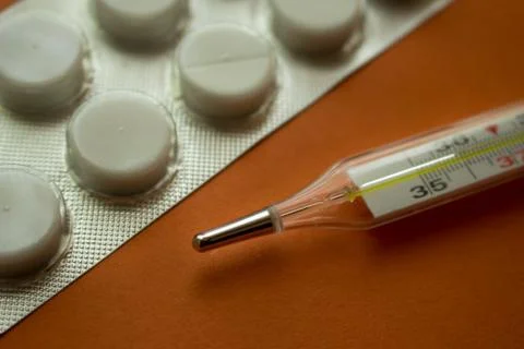 Thermometer and tablets Stock Photos