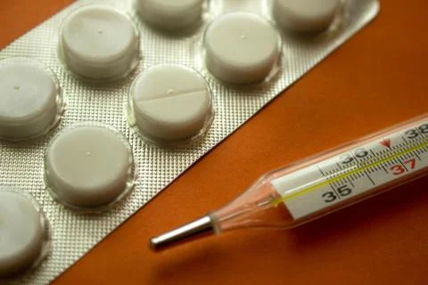 Thermometer and tablets Stock Photos