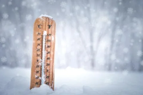Thermometer with Celsius scale placed in a fresh snow Stock Photos