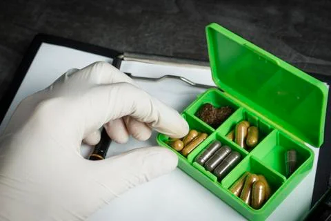 The thermometer in the hand on a background of pills Stock Photos