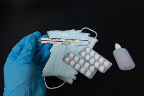 Thermometer in hand on a black background Stock Photos