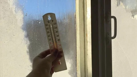 Thermometer for measuring temperature in hand against the background of an old Stock Footage 326734967
