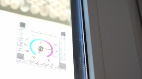 The thermometer outside the window shows a high temperature outside; the heat is Video stock 342422960
