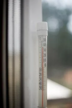 The thermometer outside the window shows more than forty degrees of heat Stock Photos