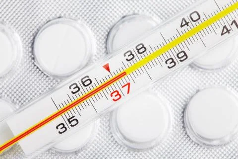 Thermometer on pills Stock Photos