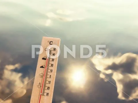 Thermometer showing 30 degrees of heat against the backdrop of lake water wit Stock Photos