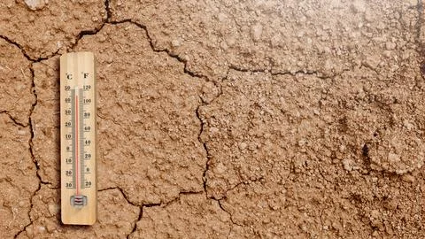 Thermometer showing high temperature on cracked, dry and parched soil, repr.. Ilustración de archivo