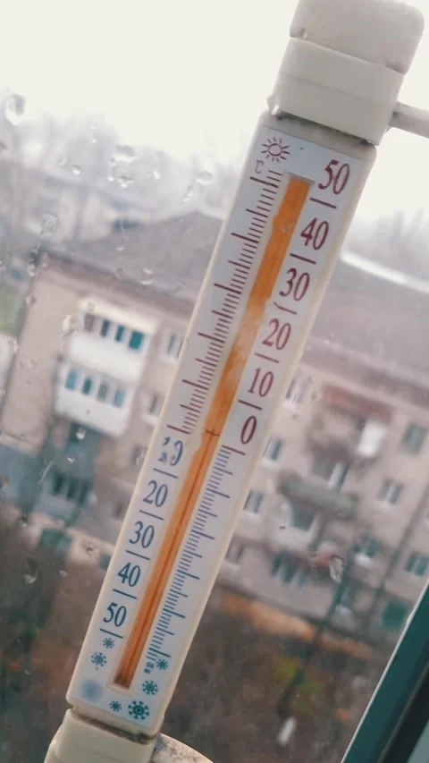Thermometer Shows Below Zero Degrees Celsius on Rainy Day Stock Footage 325223494