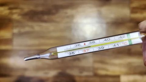 Thermometer shows elevated body temperature 37.7 Video stock 229477277