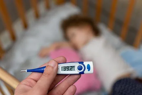 The thermometer shows a high temperature in a small child Stock Photos
