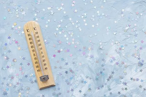 Thermometer shows low plus temperature and Christmas decoration. Winter holiday Stock Photos