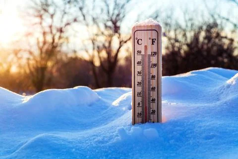 Thermometer in the snow shows zero temperature before spring against Stock Photos