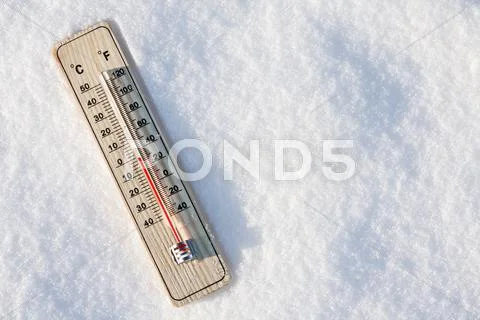 Thermometer in the snow with zero temperature Stock Photos