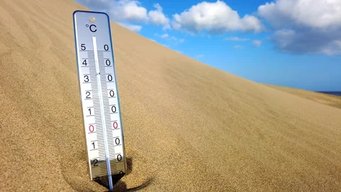 A thermometer is stuck in the hot sand of a dune against a blue sky. Stock Footage 264803343