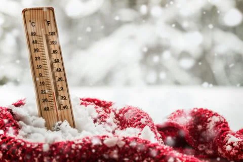 Thermometer with sub zero temperature sticks out in a snowdrift Stock Photos