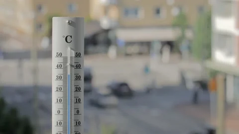 Thermometer with traffic in the background shows increasing temperature. Stock Footage 202130901