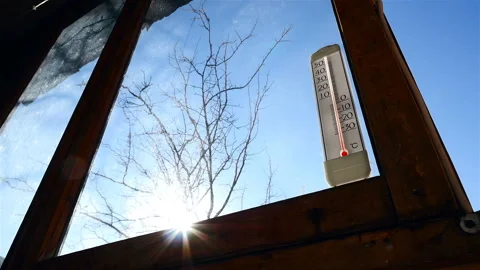 Thermometer on the window in the background of the sun. Beautiful sun glare Stock Footage 87871316