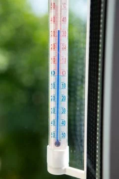 A thermometer on a window frame shows high temperatures of 35 degrees during an Stock Photos