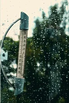 The thermometer on the of the window, the rain poured. Stock Photos