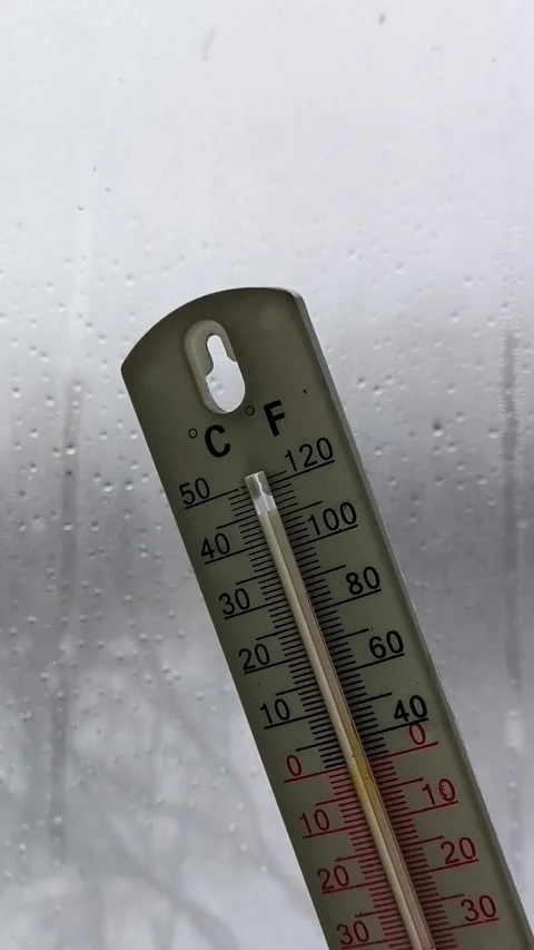 Thermometer in a womans hand against the background of a window with raindrops Stock Footage 326735258