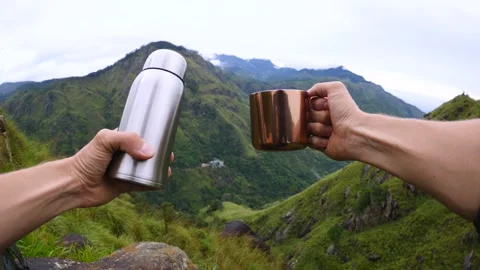 Thermos and tin mug in hands tourists against backdrop green mountains Sri Lanka Stock Footage 278123779