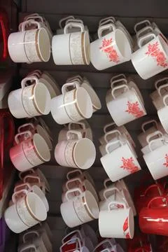 These ceramic white coffee cups display unique patterns like floral and paisl Stock Photos