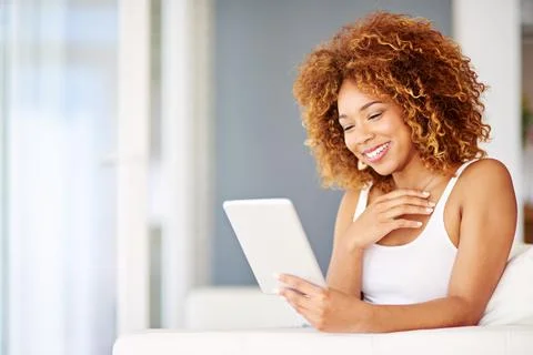 These comments are crazy. a young woman using a laptop on the sofa at home. Stock Photos