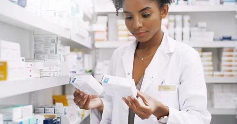 These two are easy to confuse. an attractive young pharmacist comparing two Stock Photos