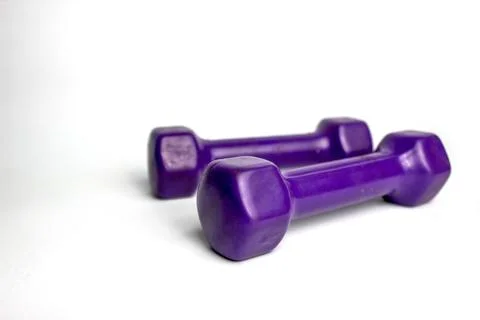 These two purple vinyl coated dumbbells are perfect for a home fitness routine. Stock Photos