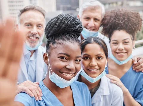 They aim to provide the best medical care. a group of doctors taking a selfie in Stock Photos