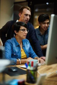 They all share the same vision. employees working in an office at night. 写真素材