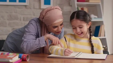 They are learning to write to the mother and daughter wearing a headscarf. Stock Footage 145495641